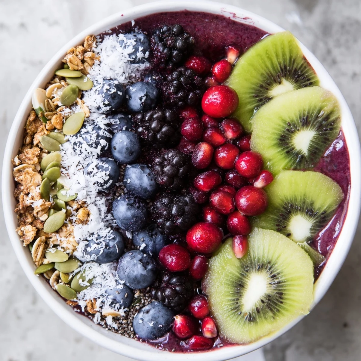 A close-up of a vibrant Winter Berry Smoothie Bowl with Seeds topped with fresh berries and crunchy seeds.