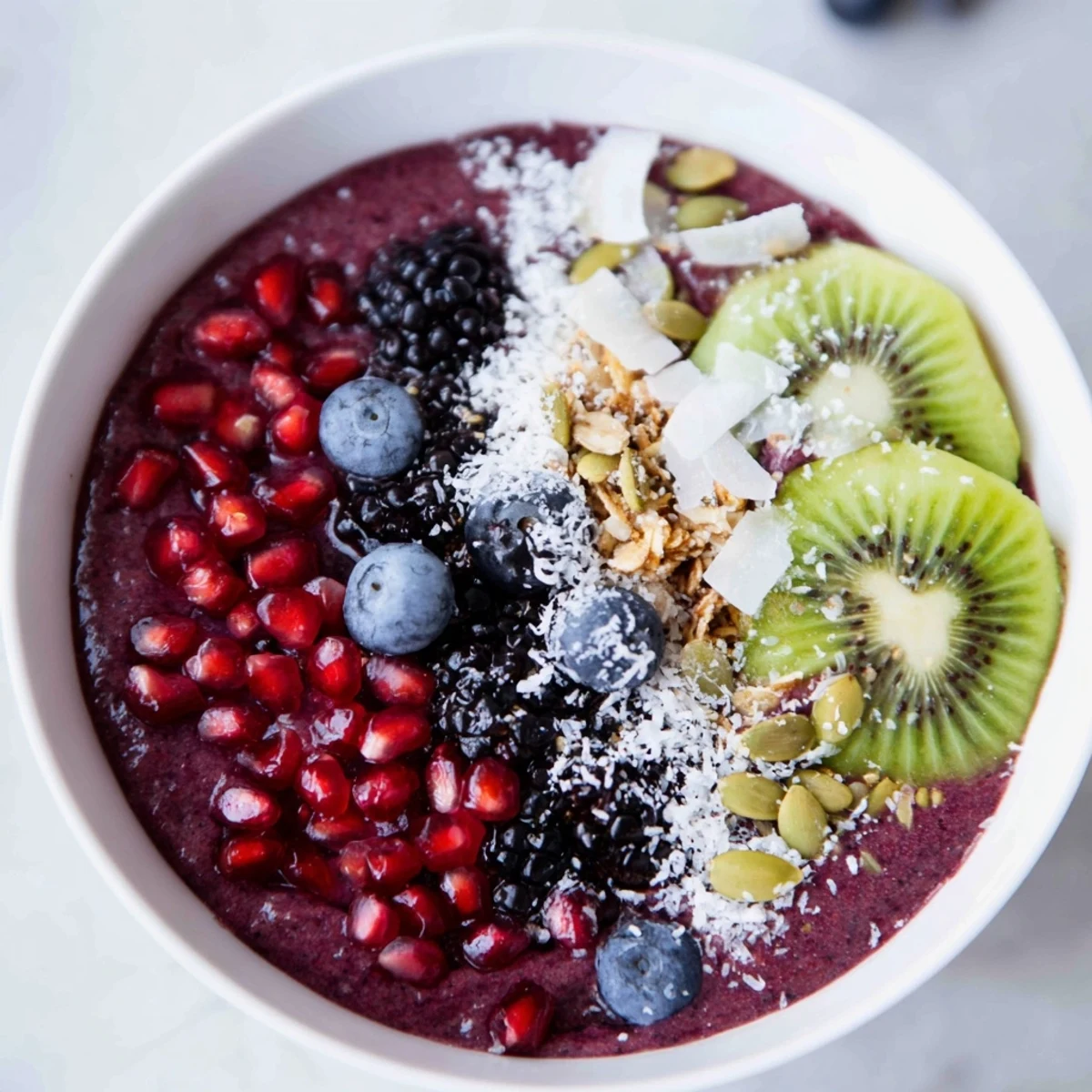 Thick Winter Berry Smoothie Bowl with Seeds layered with Greek yogurt and sprinkled with pumpkin and sunflower seeds.