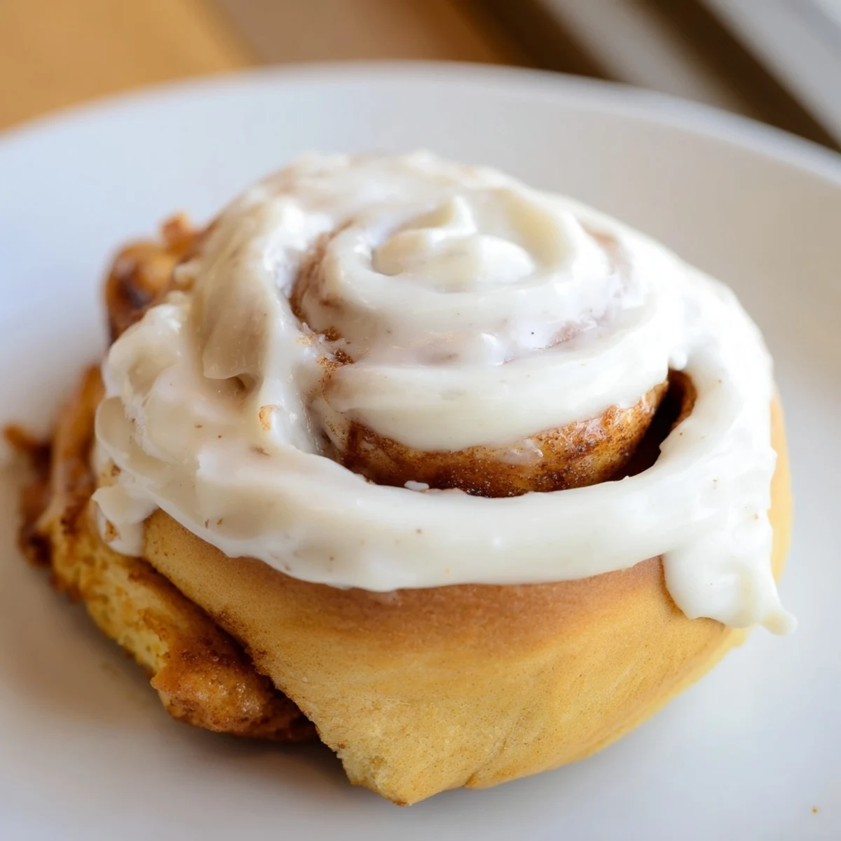 Decadent Keto Cinnamon Buns drizzled with cream cheese icing, ready to be enjoyed with a hot cup of black coffee.