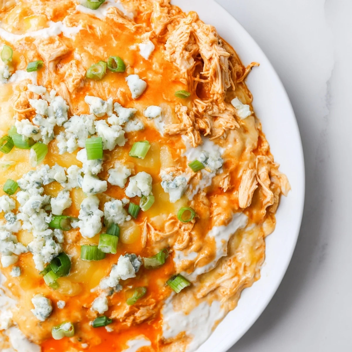 Golden baked Keto Buffalo Chicken Dip with melted cheddar and mozzarella, served warm with crunchy celery sticks for dipping.