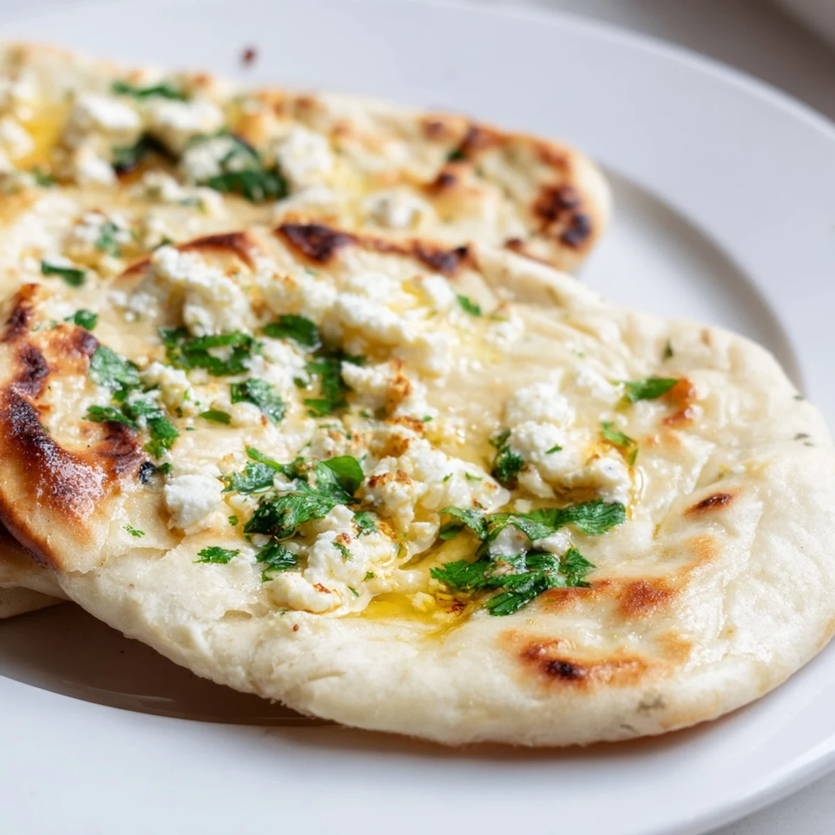 Golden-brown Cottage Cheese Garlic Naan topped with fresh cilantro, brushed with melted butter and minced garlic.
