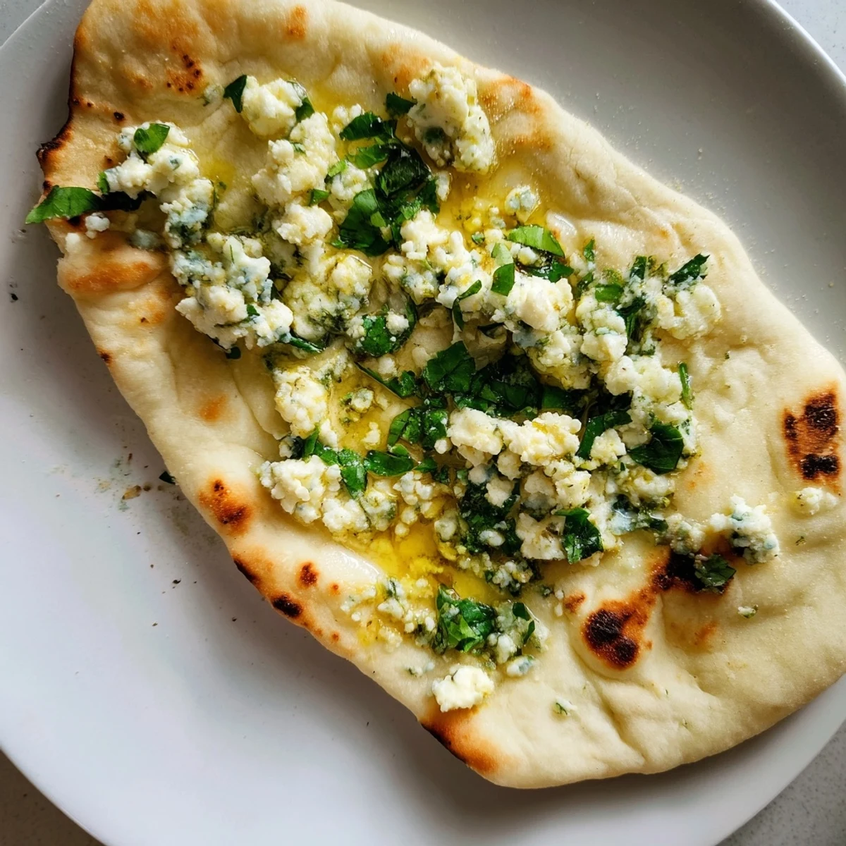 Soft, pillowy Cottage Cheese Garlic Naan sizzling in a skillet with garlic butter, ready to be enjoyed.