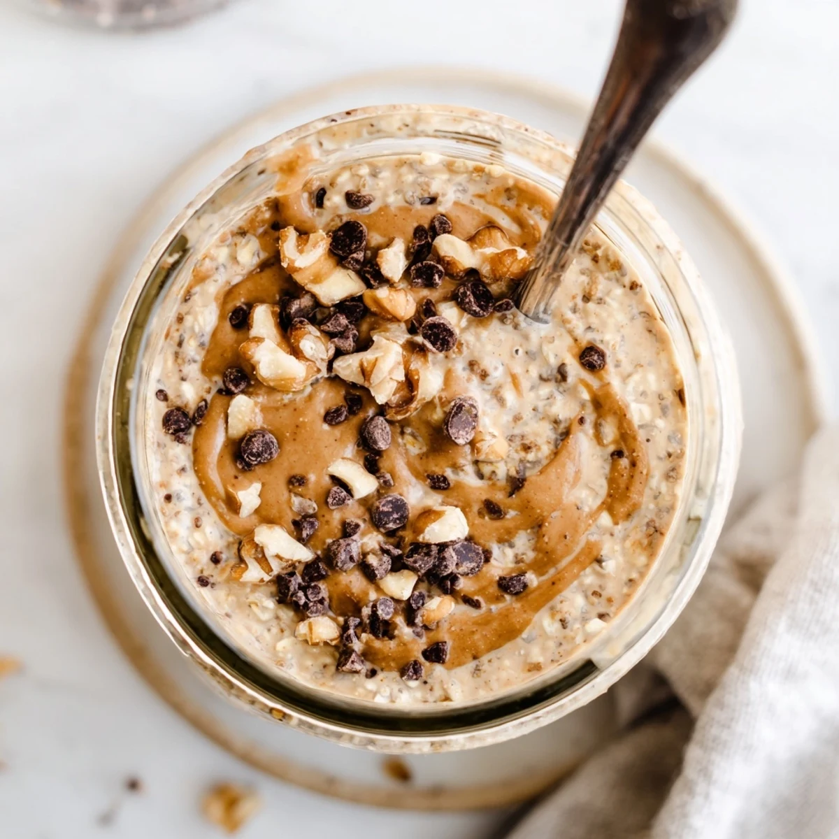 Stirred jar of Cookie Dough Overnight Oats showing rolled oats, Greek yogurt, and chocolate chips ready to enjoy.