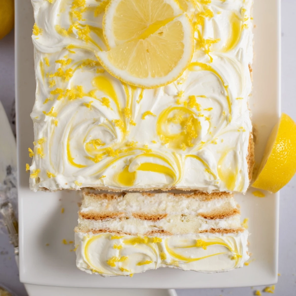 Slice of Lemon Limoncello Italian Tiramisu with a dollop of lemon curd and a thin lemon slice garnish.