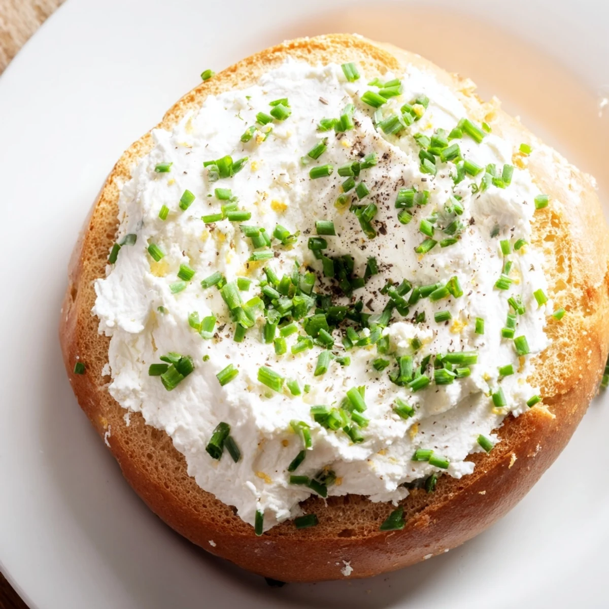 A close-up view of golden Protein Bagels with Cottage Cheese, served on a plate with cracked black pepper.
