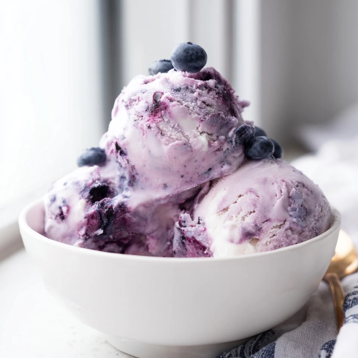 Easy no-churn Blueberry Cottage Cheese Ice Cream served in a dish, highlighting its smooth texture and purple hue.
