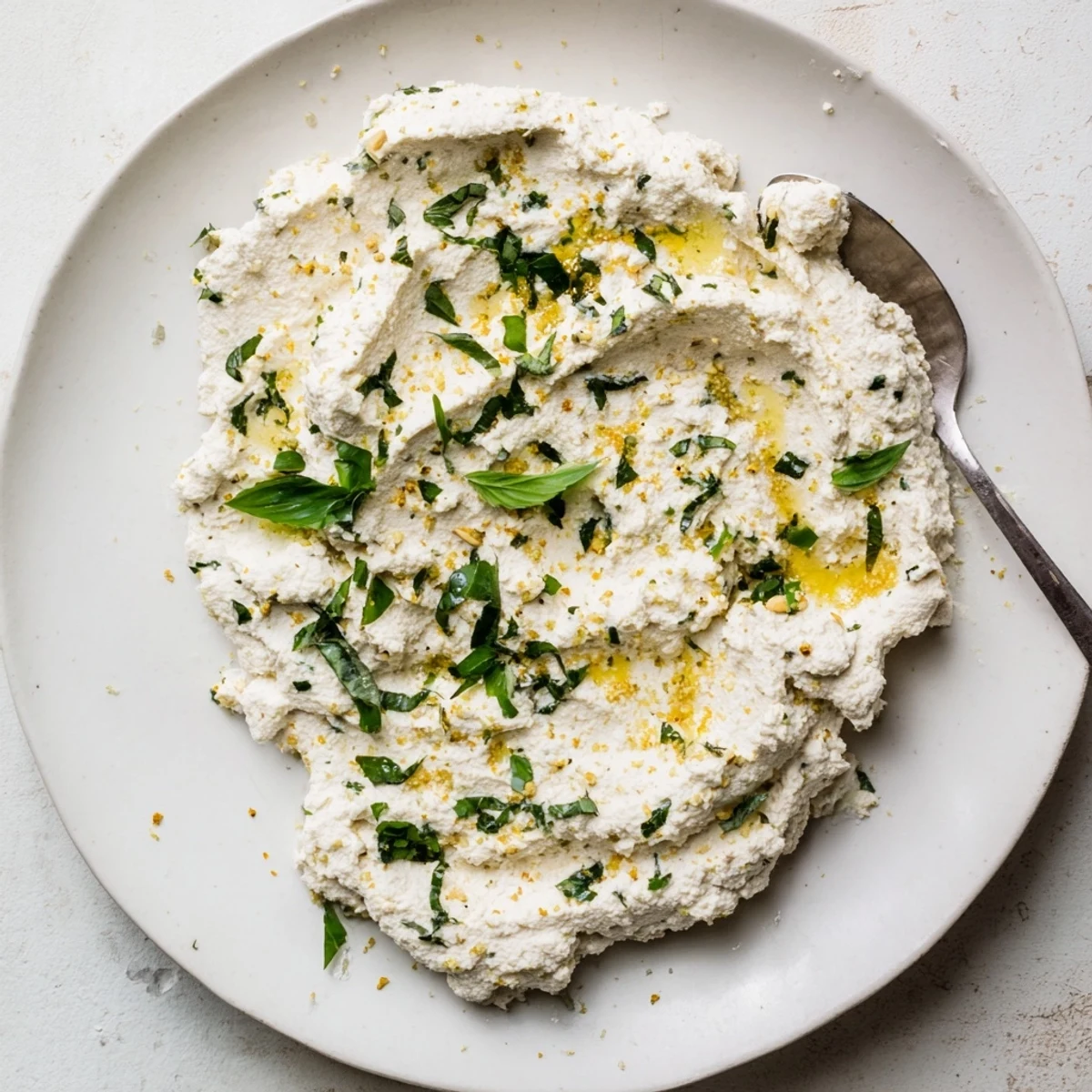 A bowl of freshly made Tofu Ricotta garnished with basil, ideal for stuffing pasta shells.