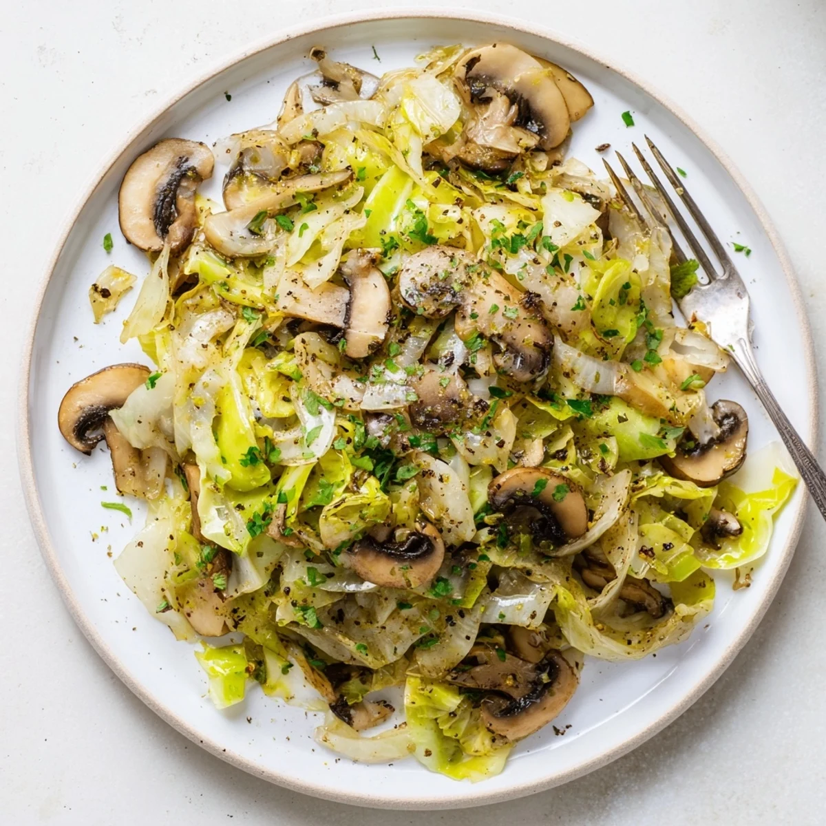 Vegetarian cabbage mushroom sauté served in a rustic bowl with a lemon wedge, ready to be enjoyed as a hearty side.