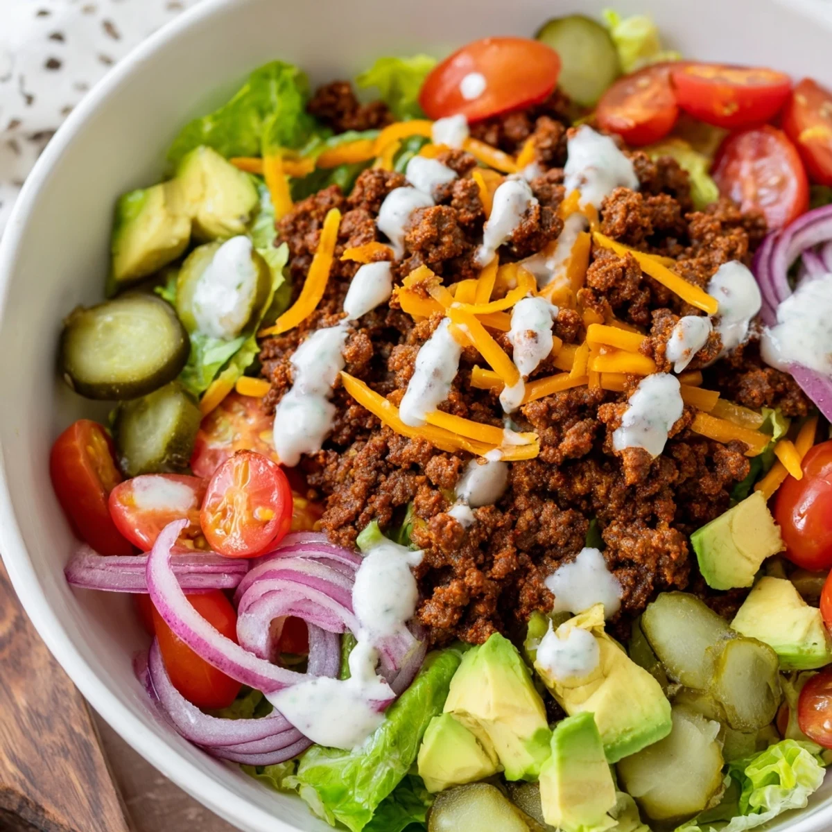 Colorful burger bowls layered with seasoned ground beef, fresh lettuce, tomatoes, and creamy special sauce