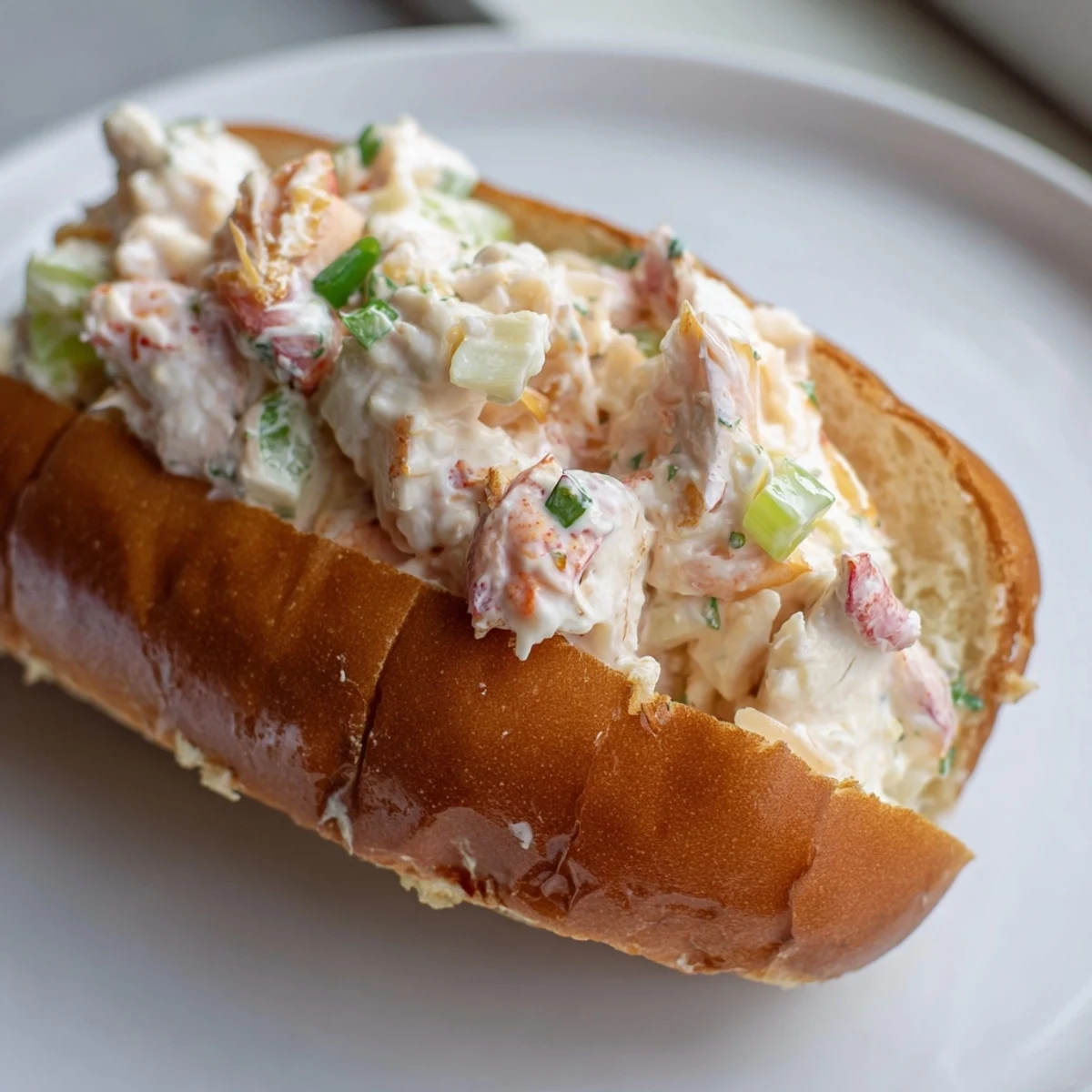 Split top sandwich overflowing with tender lobster meat in mayonnaise dressing on buttery grilled rolls