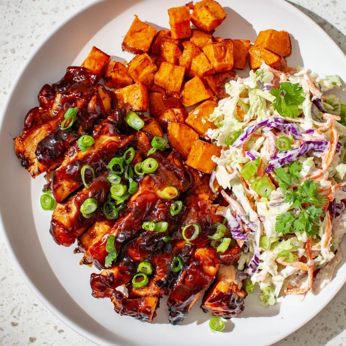 Colorful BBQ chicken bowls with roasted sweet potatoes and crunchy purple cabbage coleslaw