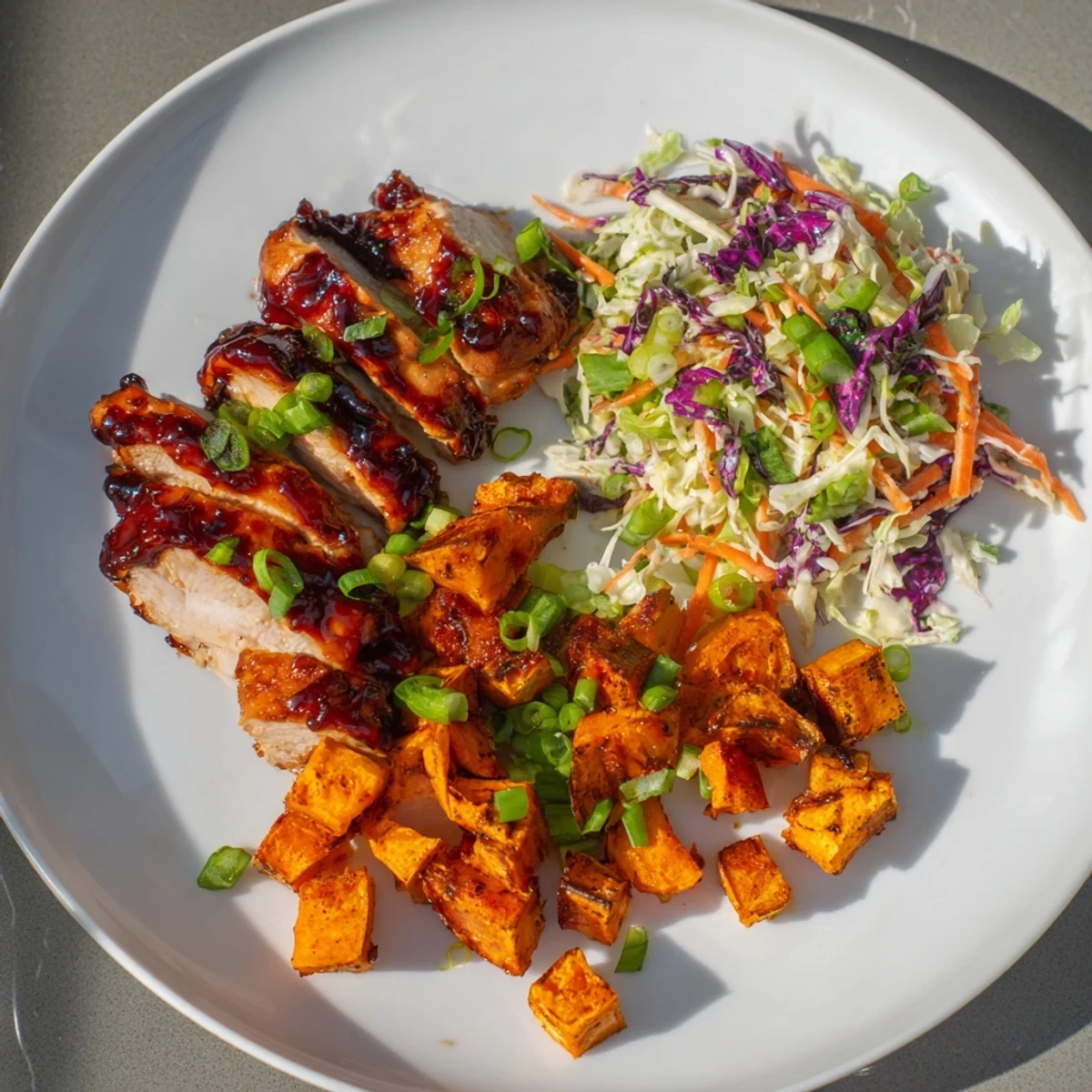 Flavor-packed meal of glazed BBQ chicken, golden roasted sweet potatoes, and crisp vegetable slaw