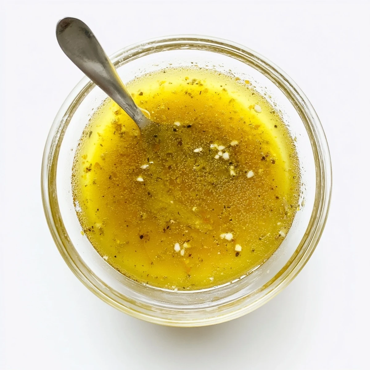 Easy lemon vinaigrette dressing emulsified in mason jar with whisk on wooden countertop