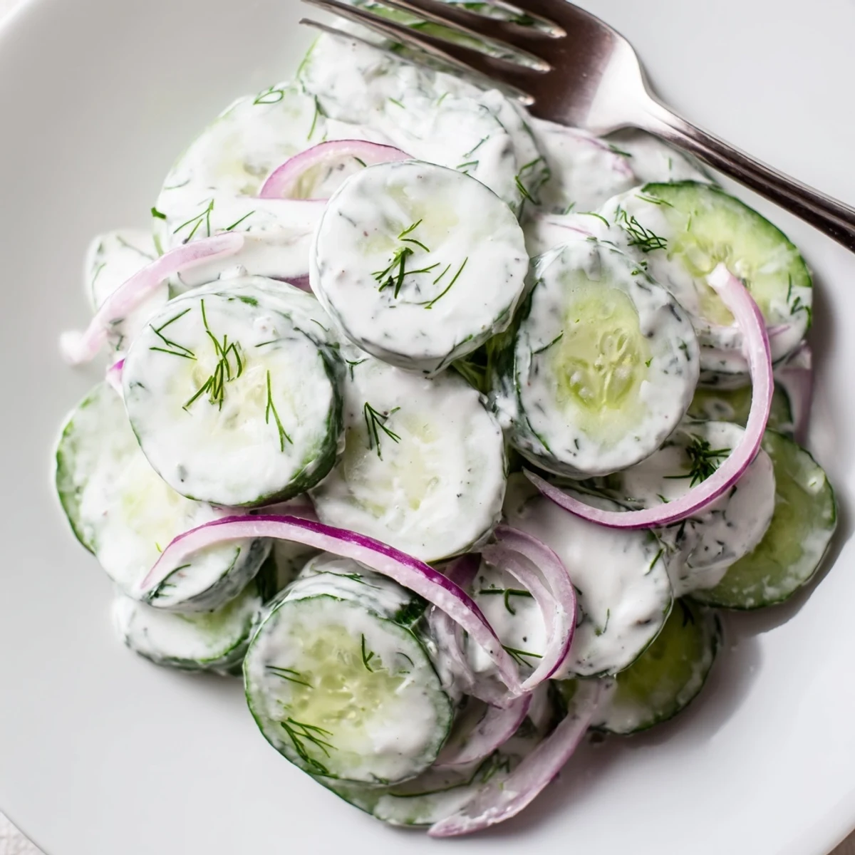 Creamy cucumber salad featuring crisp sliced cucumbers in a tangy sour cream dressing with fresh dill