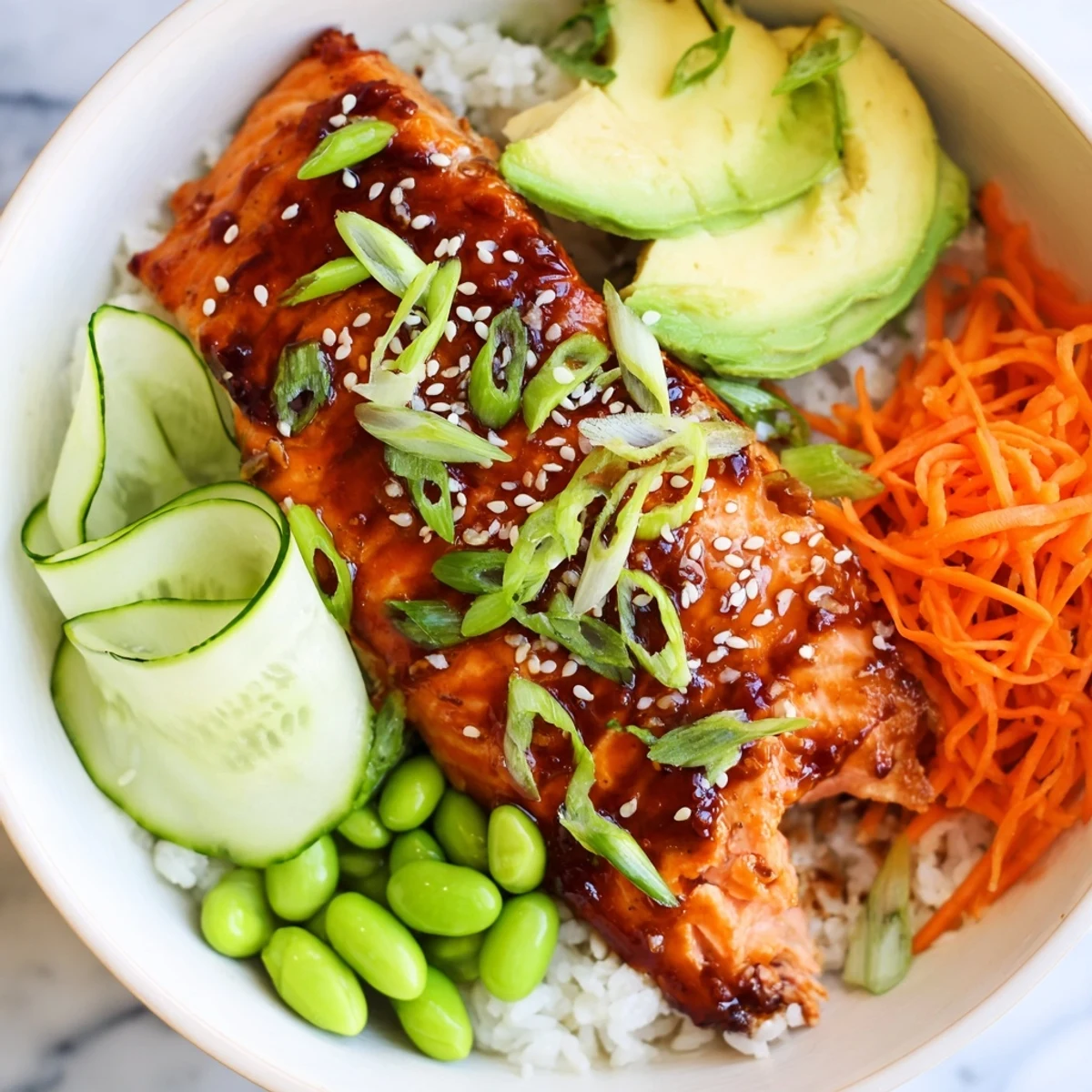 Glistening honey glazed salmon bowl featuring tender fish fillet surrounded by fresh edamame carrot and avocado