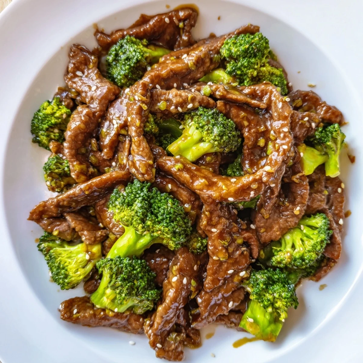 Dark savory beef and broccoli stir fry sauce drizzled over sizzling beef and crisp broccoli pieces