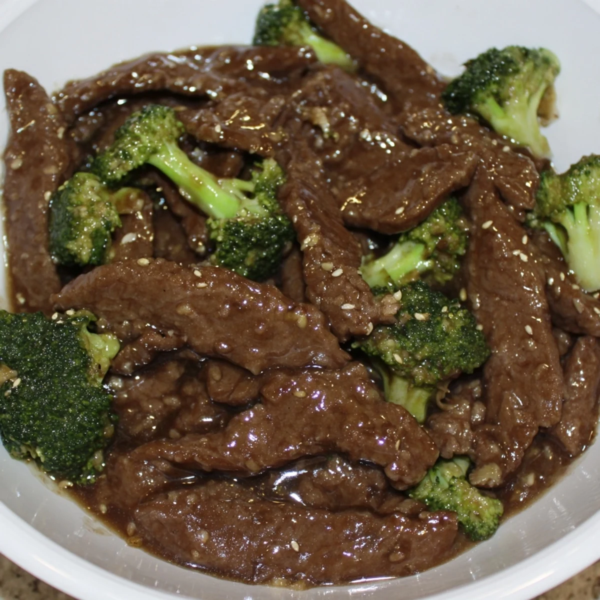 Thick umami beef and broccoli stir fry sauce glazed on beef and fresh broccoli in wok