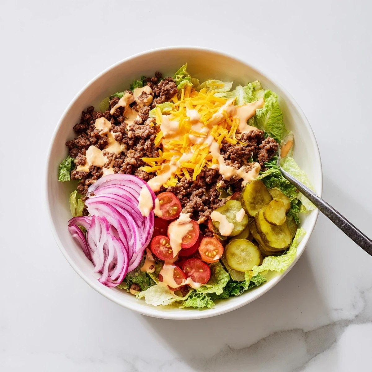 Golden brown ground beef Burger Bowls topped with melted cheddar and fresh vegetables