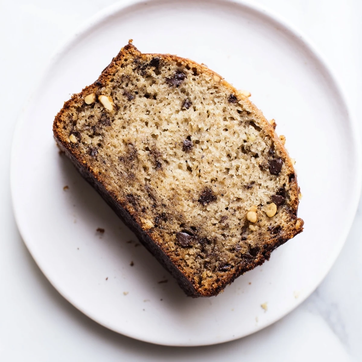 Homemade super moist banana bread displaying its rich texture and perfect golden crust, ready for breakfast or snacking