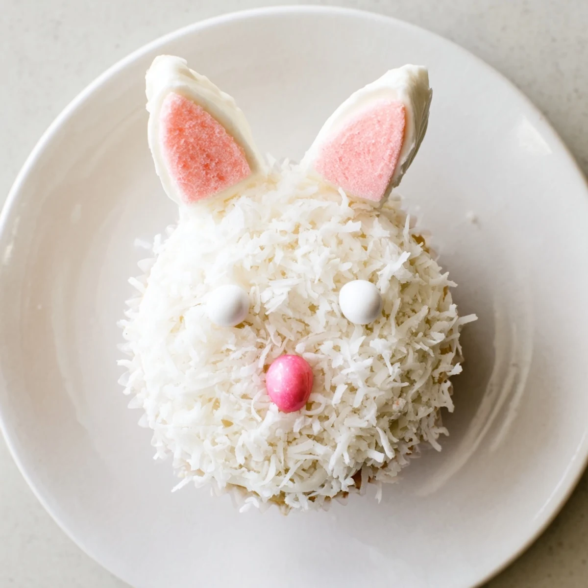 Spring-inspired bunny cupcakes featuring buttercream frosting, coconut coating, and cute edible candy decorations