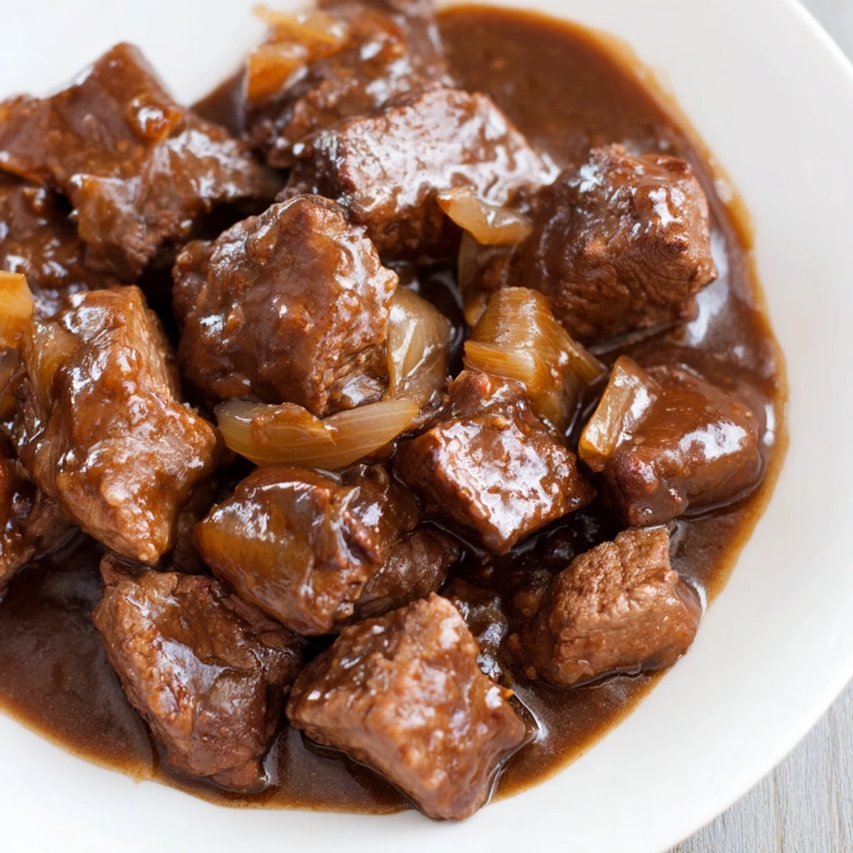 Slow cooker beef tips and gravy served over fluffy mashed potatoes with fresh parsley garnish