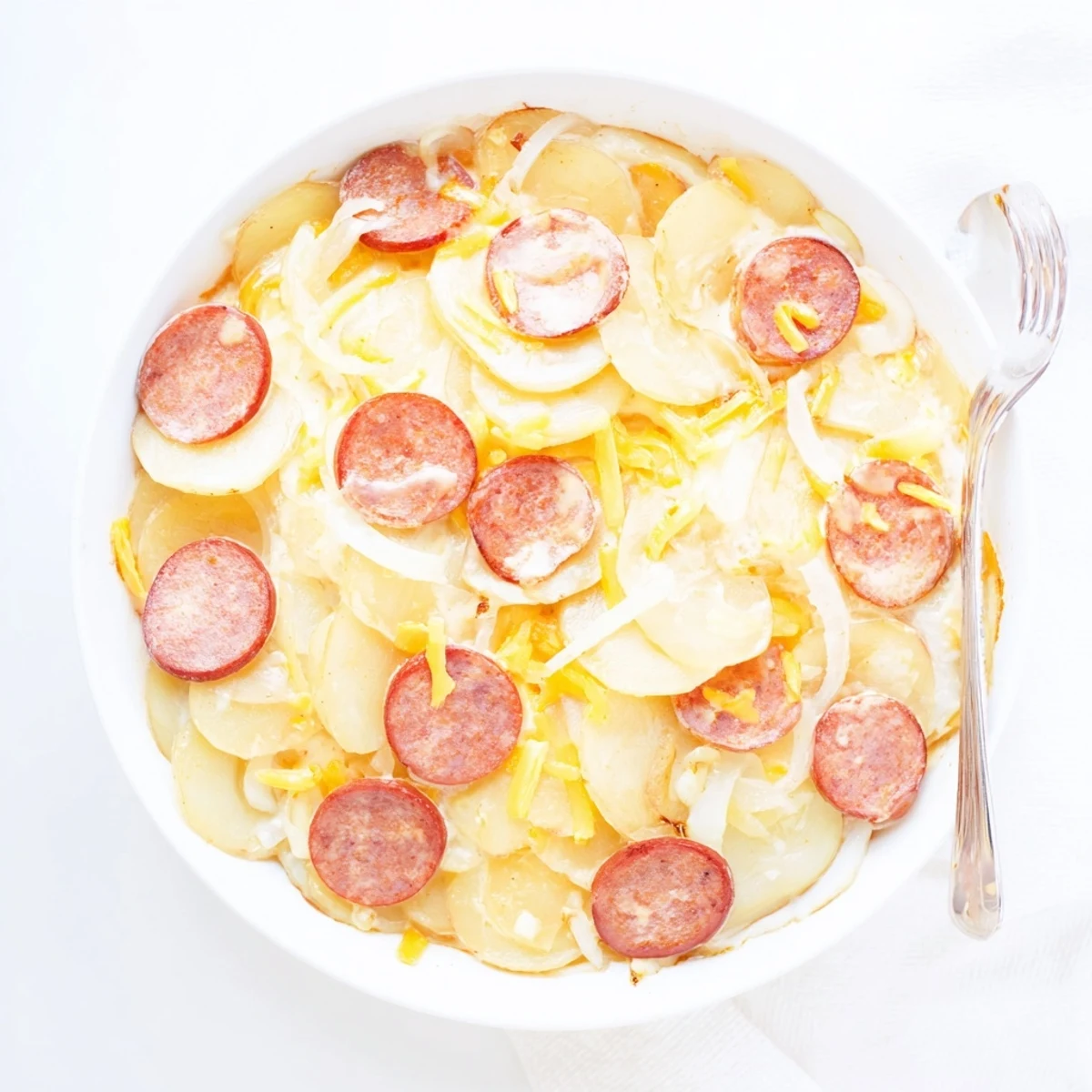 Hearty slow cooker scalloped potatoes kielbasa topped with golden melted cheddar and sliced sausage