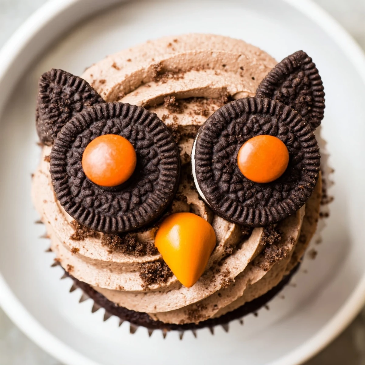 Charming Oreo Owl Cupcakes featuring twisted cookie eyes and orange candy beaks nestled in decorative liners