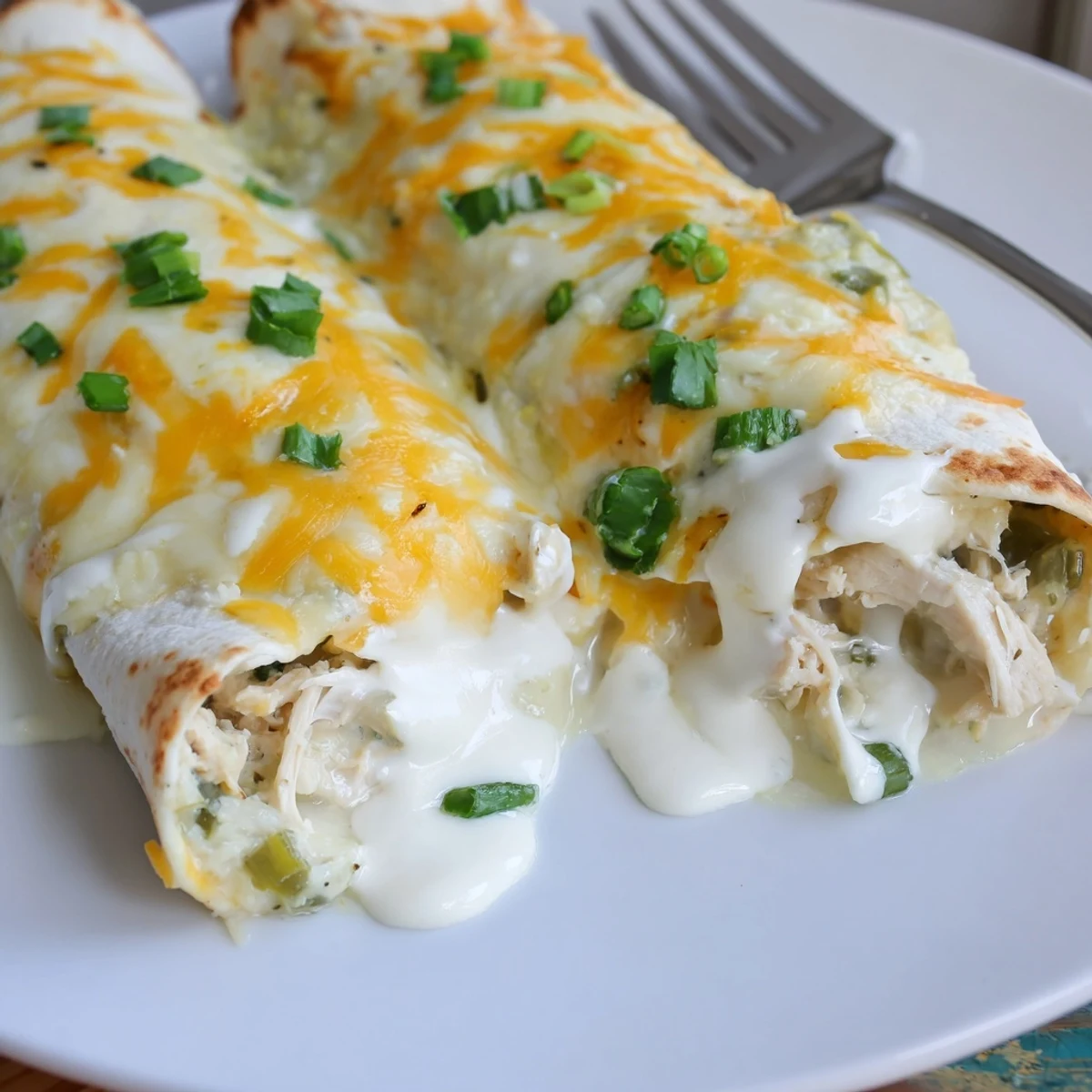 Oven baked White Rotisserie Chicken Enchiladas steaming with creamy filling and gooey cheese pull