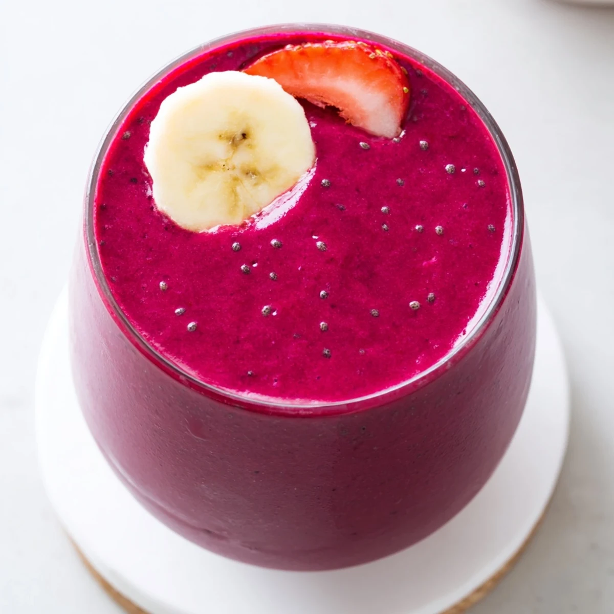 Garnished beet smoothie glass with mint sprout showcasing layered pink smoothie texture
