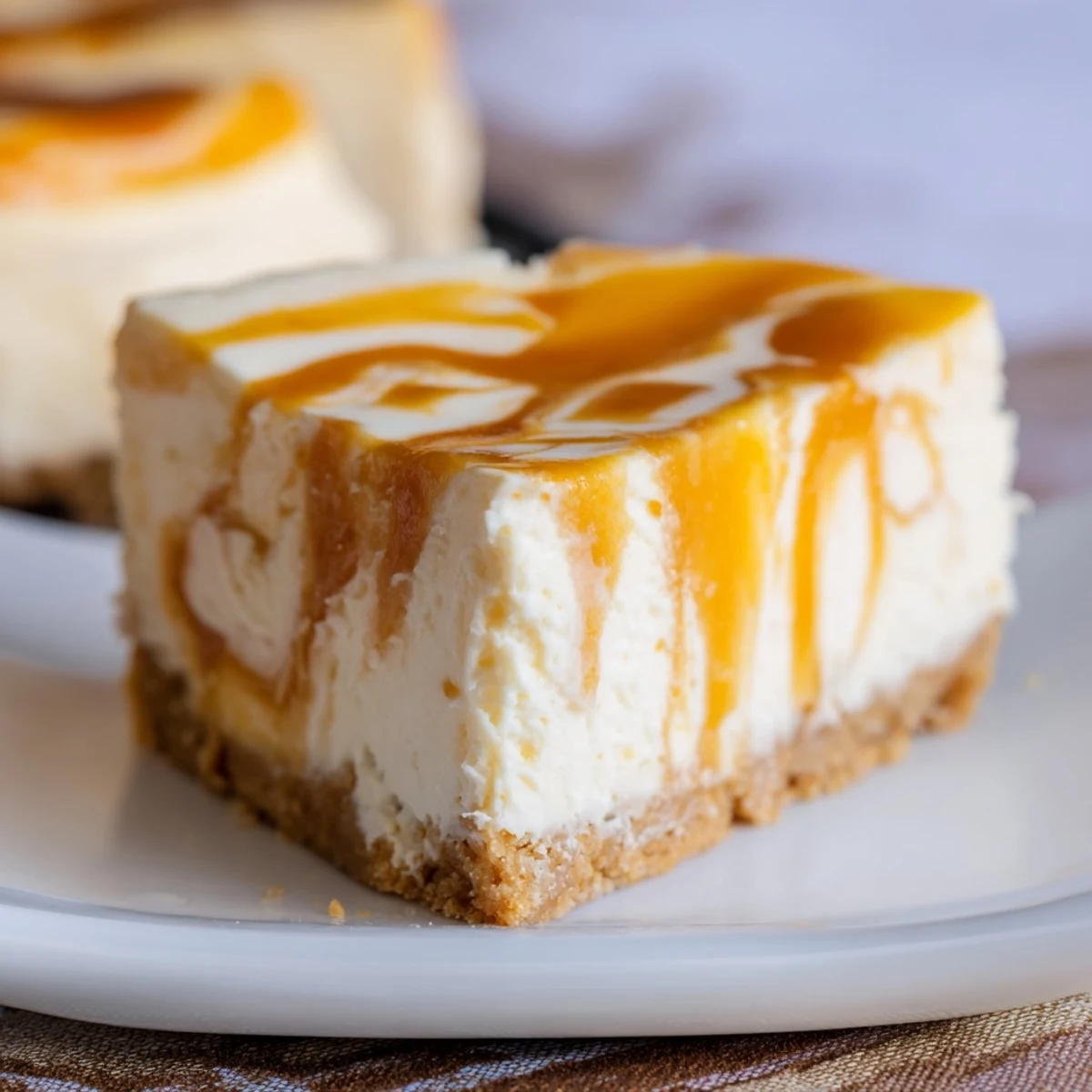 Rich homemade caramel swirl cheesecake with graham cracker crust served on marble surface