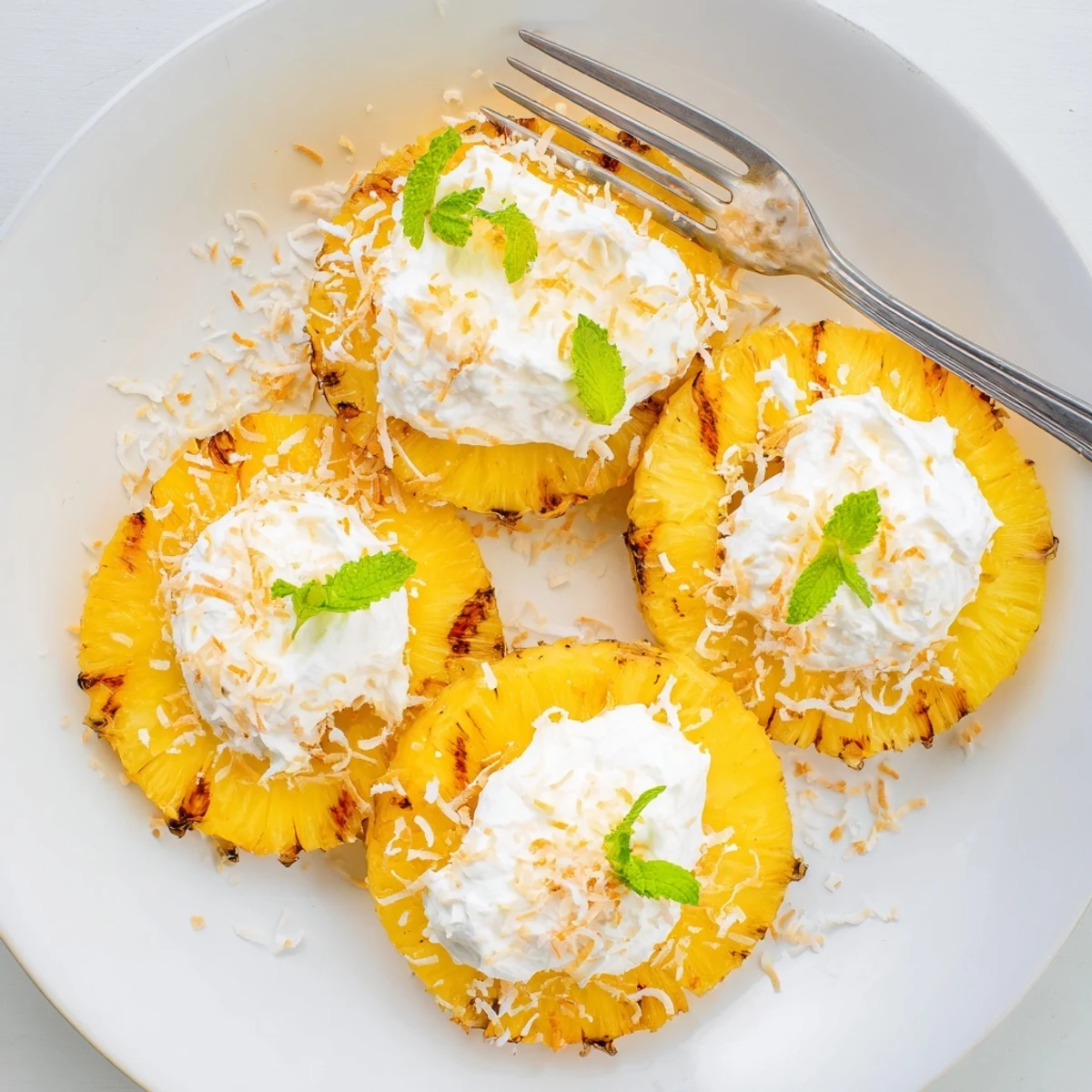 Plated Creamy Citrus Grilled Pineapple served warm, aromatic citrus cream, fresh mint.