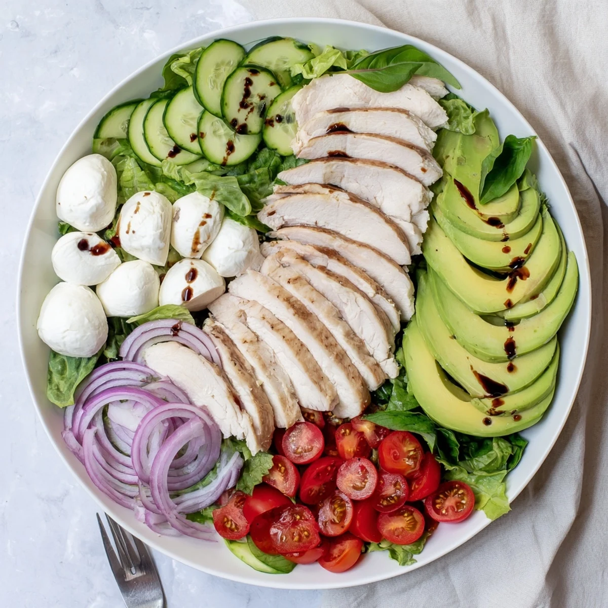 Baked Marinated Chicken Salad With Mozzarella And Balsamic Vinaigrette on plates, sliced chicken glistening.