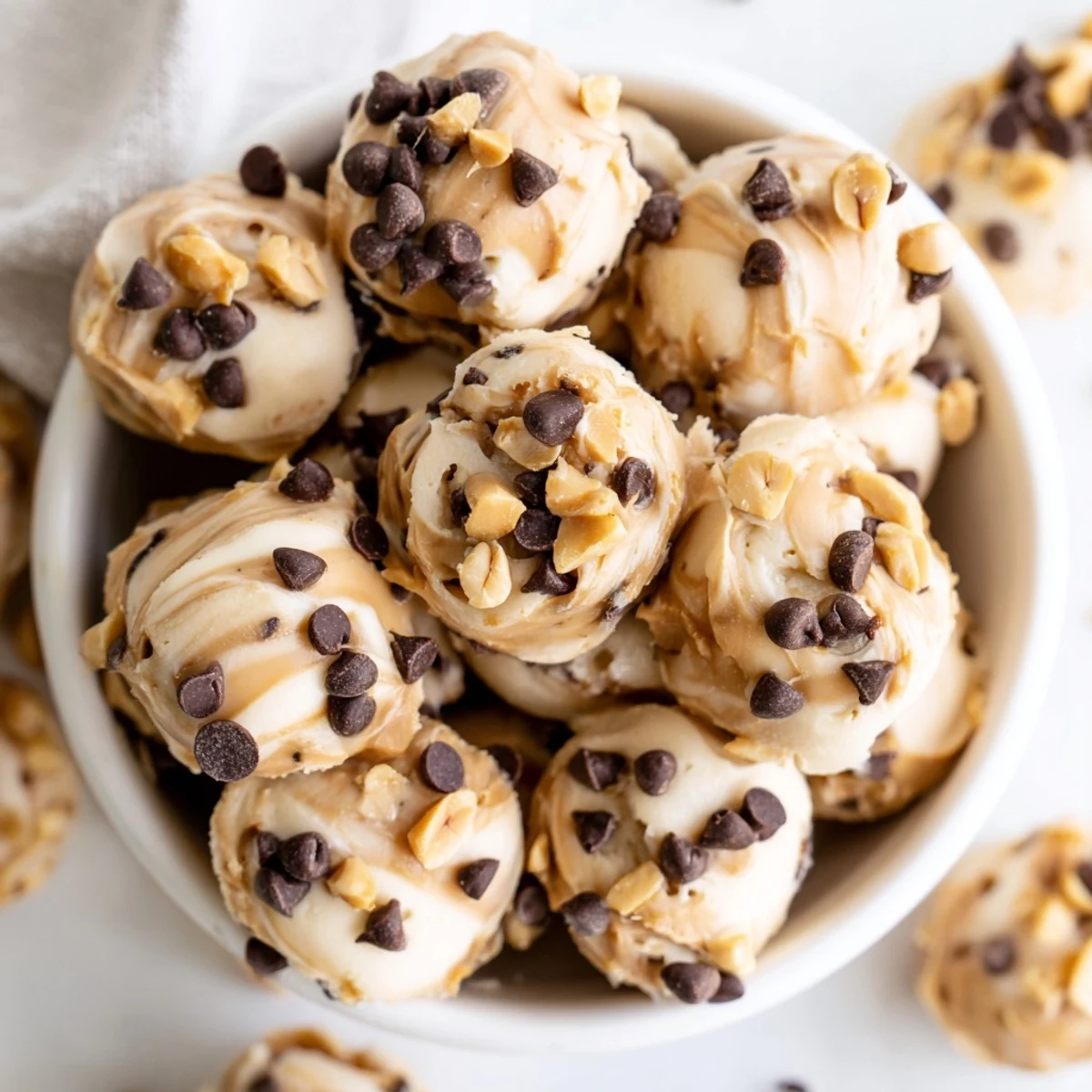 Creamy frozen peanut butter Greek yogurt bites stacked in a glass container ready for snacking