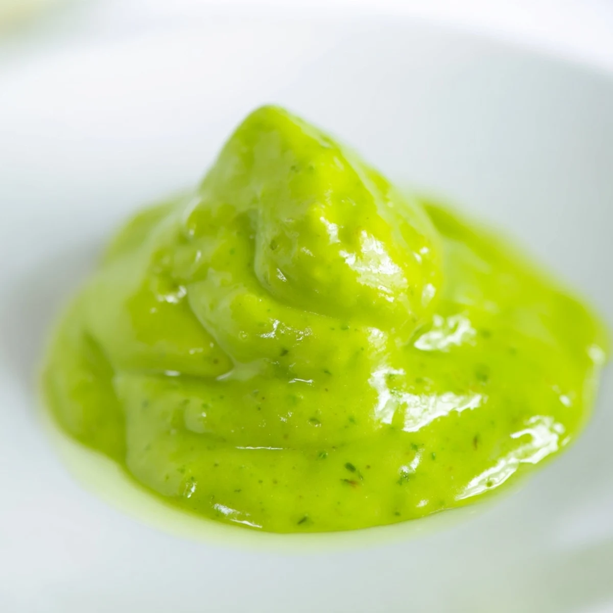 Creamy Peruvian green sauce aji verde drizzled over grilled chicken and roasted vegetables