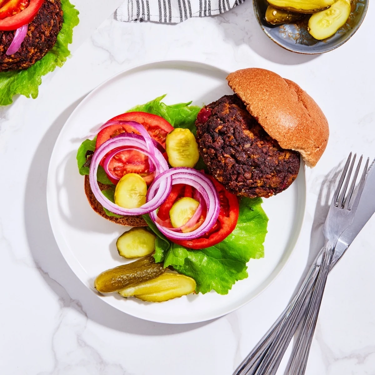 Hearty black bean veggie burgers recipe sizzling in a cast iron skillet with grilled vegetable toppings