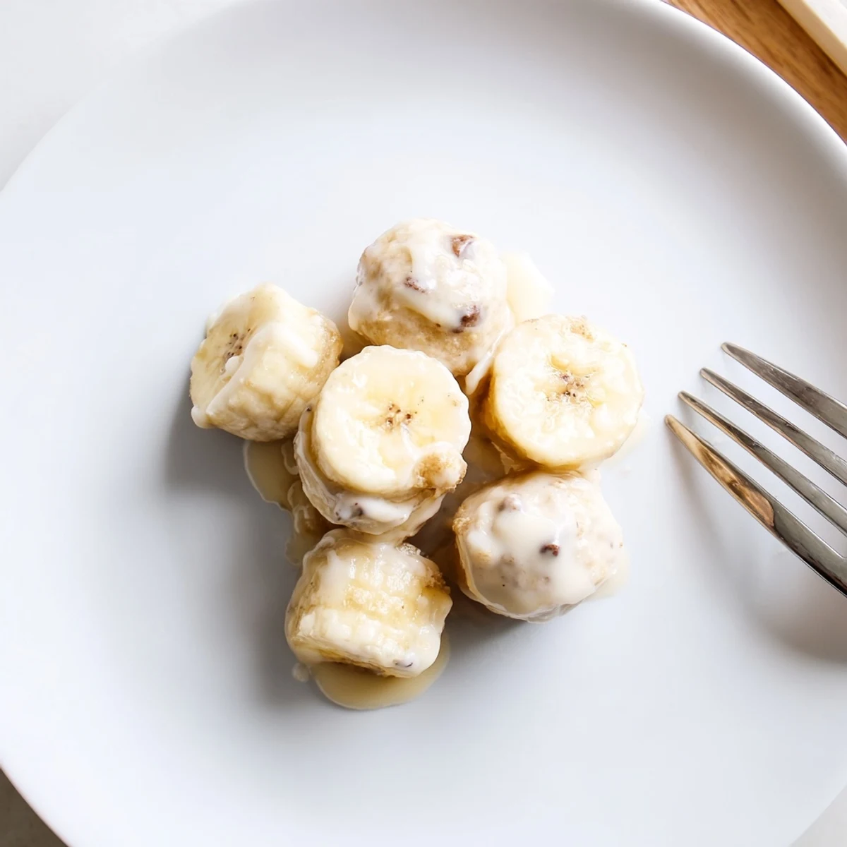 Frozen Banana Yogurt Bites on parchment, creamy coating, sprinkled with mini chips