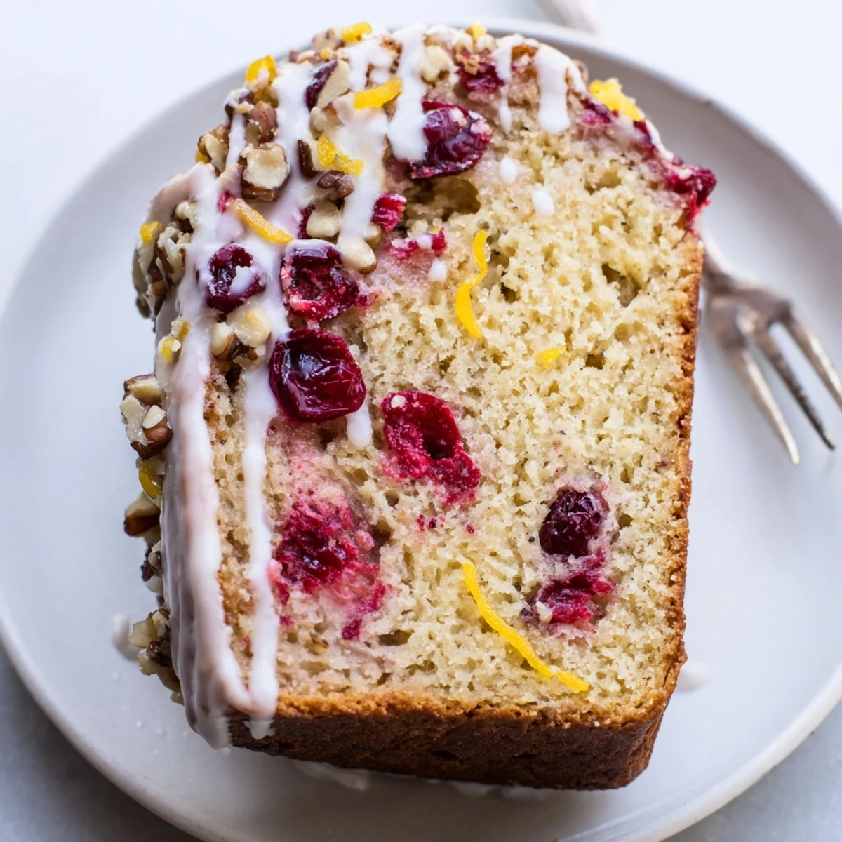 Cranberry Orange Bread cooling on a rack, bright citrus-scented slices