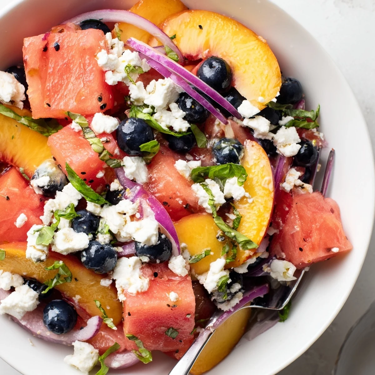Peach Watermelon Salad With Feta in a chilled bowl, juicy, mint sprinkled
