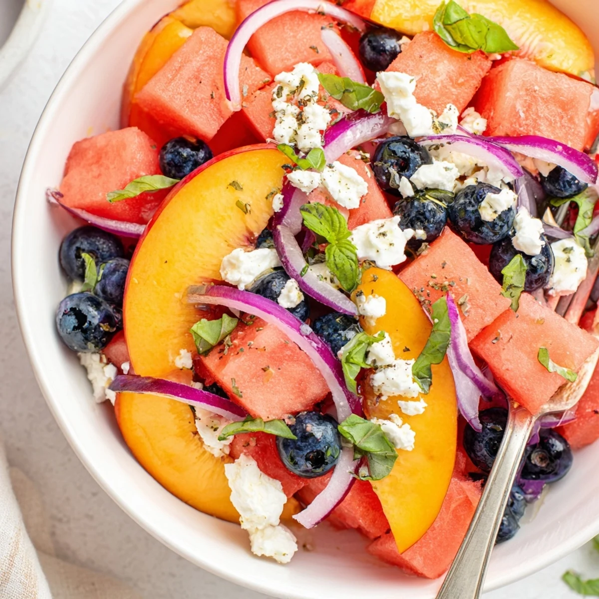 Bright, zesty lime drizzle dresses Peach Watermelon Salad With Feta, served chilled