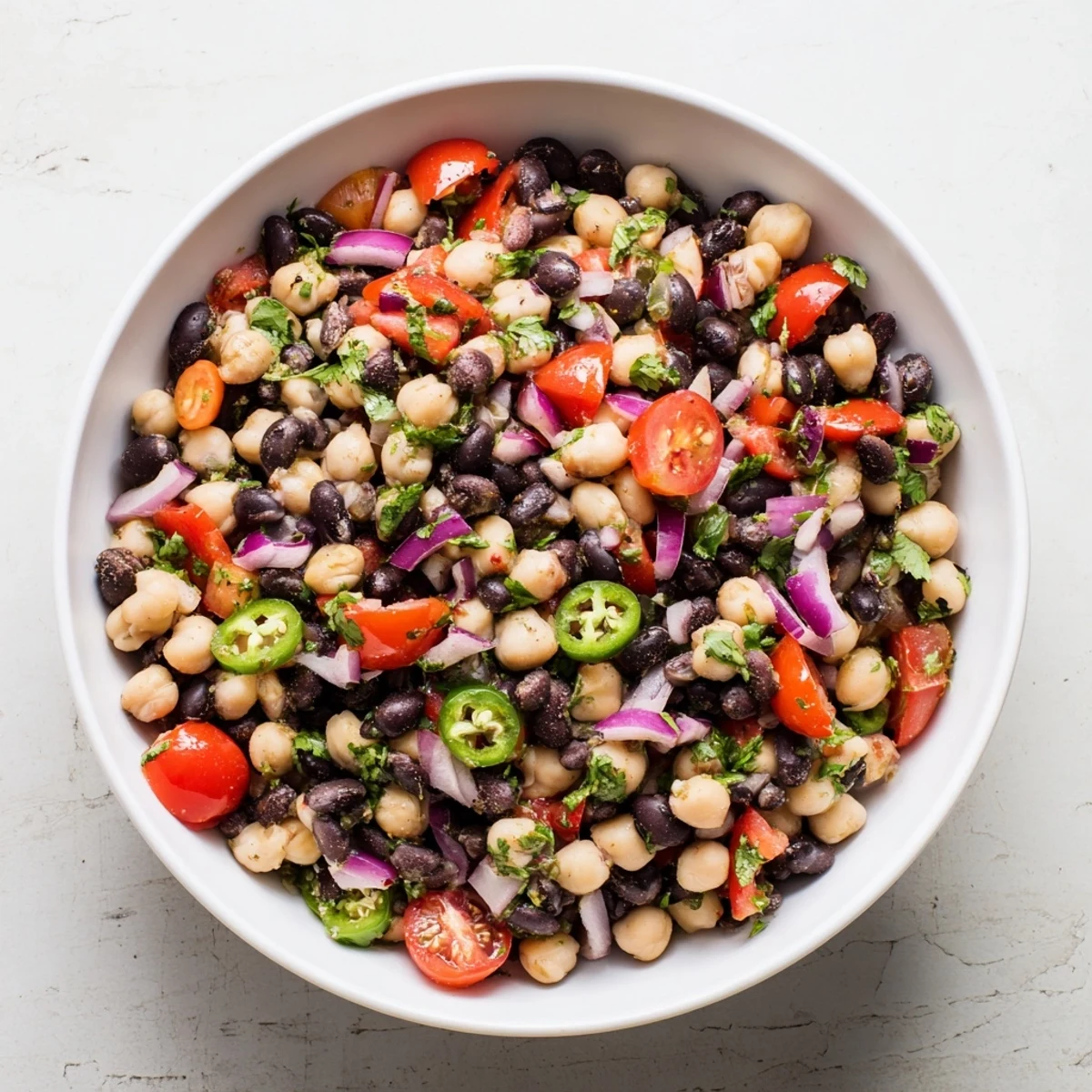 Zesty bean salad featuring black beans chickpeas and crisp vegetables dressed in lime and cilantro