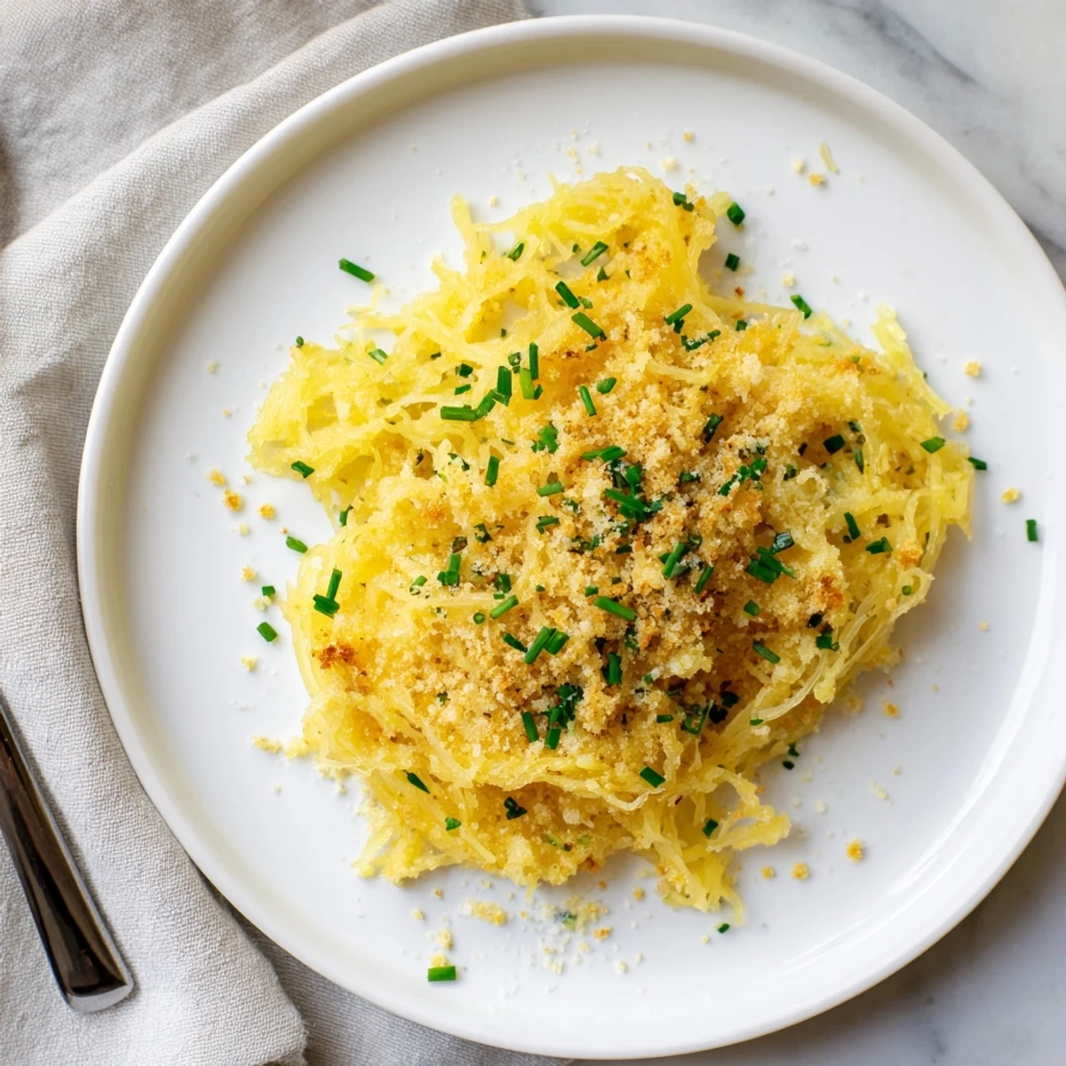 Baked spaghetti squash mac cheese with crispy breadcrumb topping and fresh chive garnish
