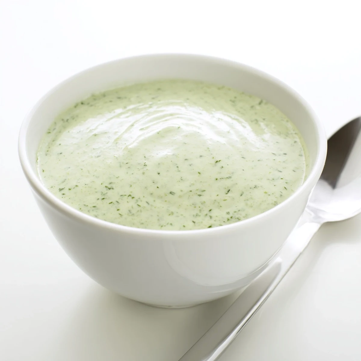 Vibrant green creamy cilantro lime sauce drizzled over tacos in a rustic bowl