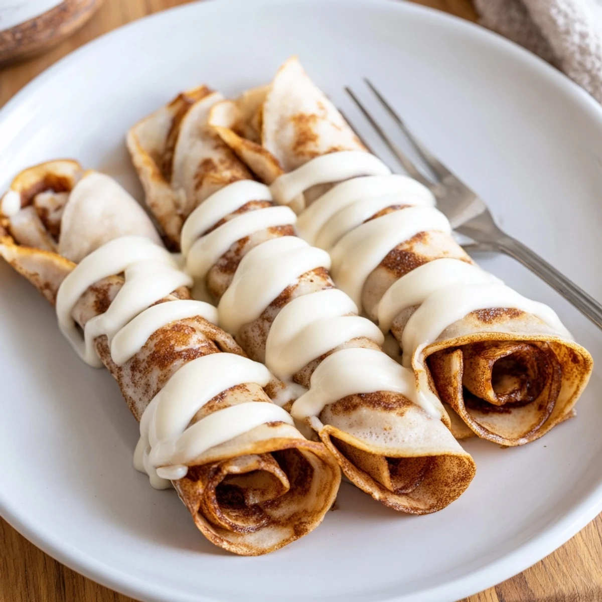Golden Cinnamon Roll Protein Crepes rolled with sweet cinnamon sugar filling close-up