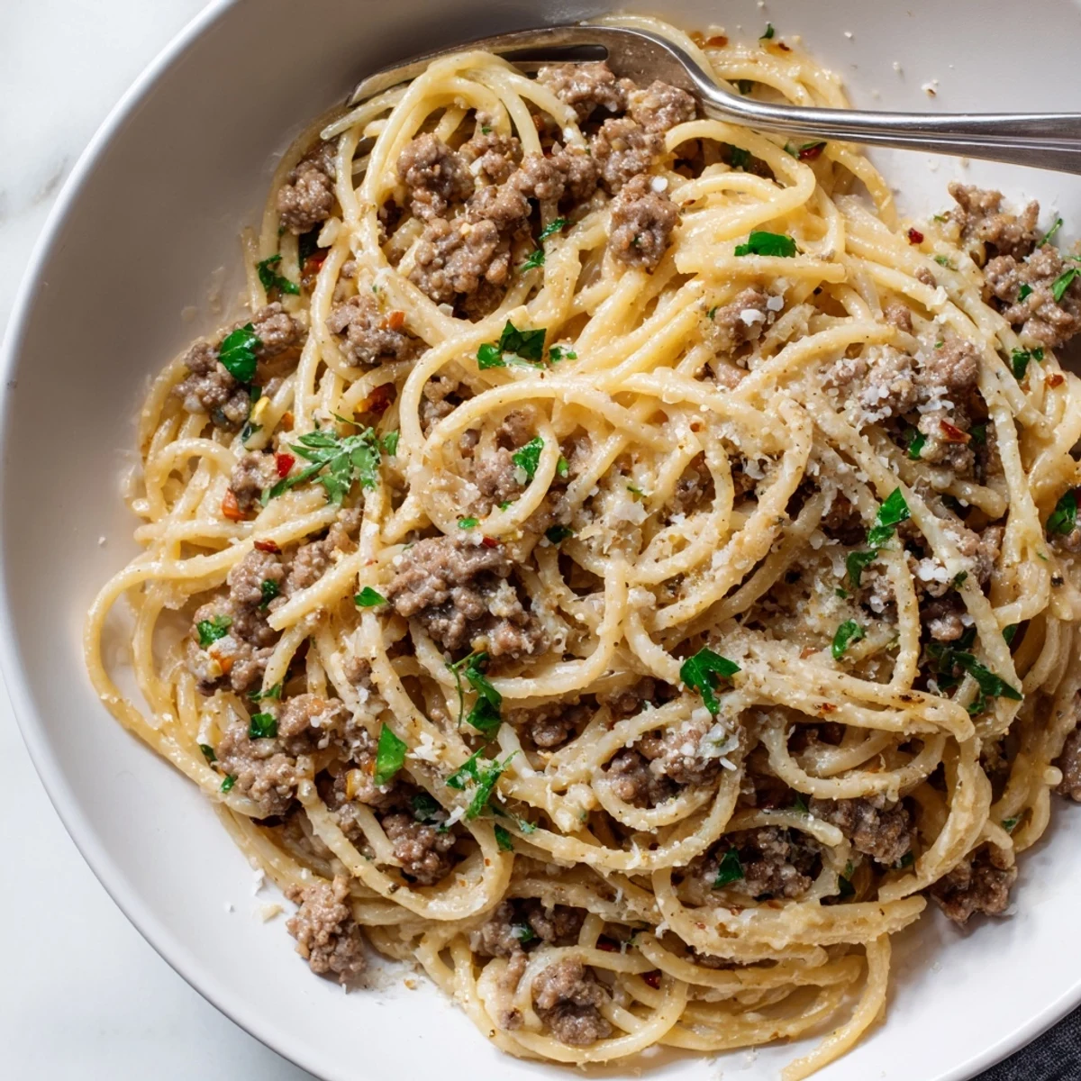 Creamy garlic butter pasta with ground beef served in a rustic skillet