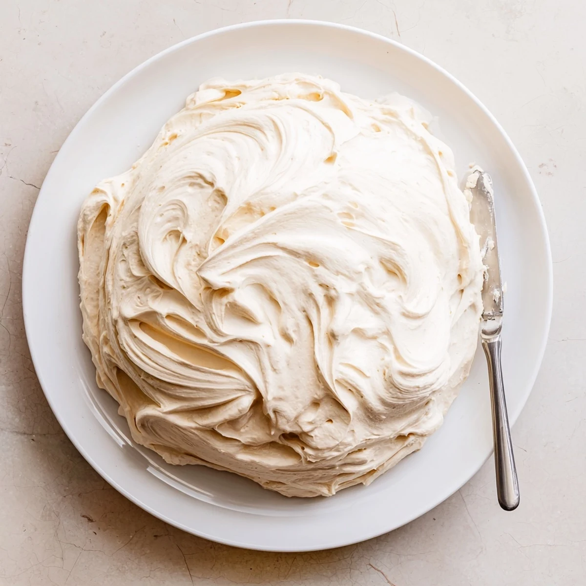 Glossy Italian meringue buttercream with pillowy texture ready for frosting decadent desserts