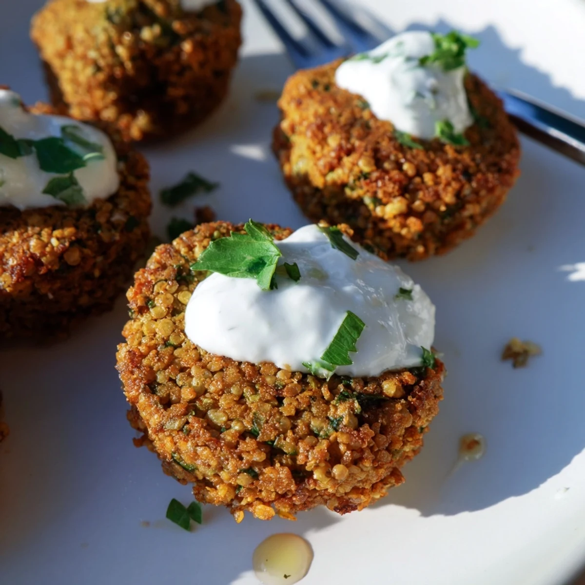 Crunchy herb falafel bites stacked in a warm pita drizzled with tangy garlic yogurt sauce.