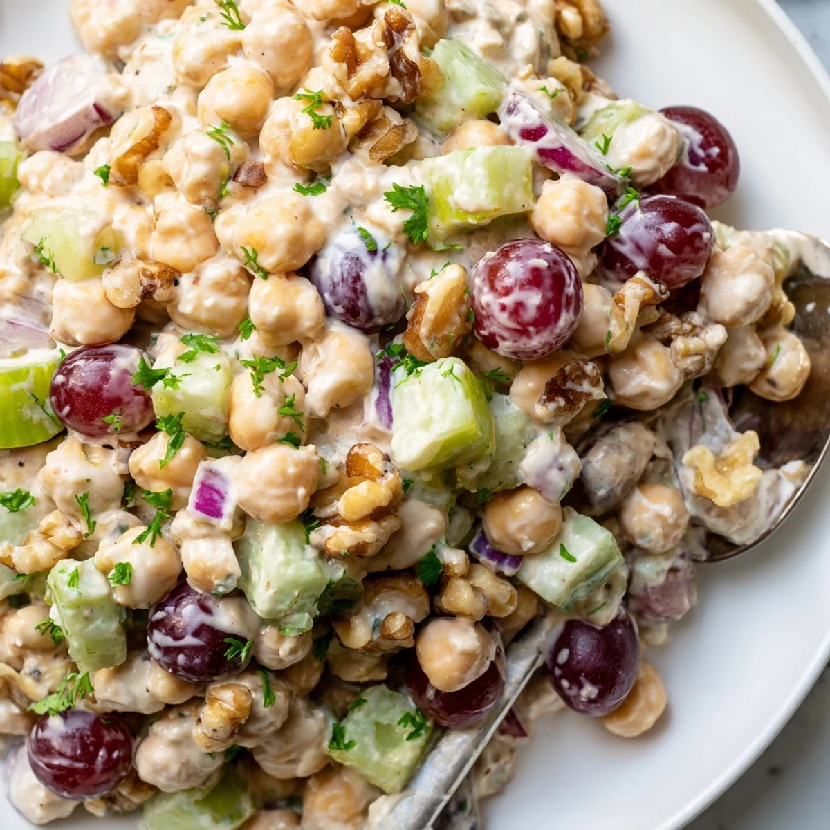 Creamy vegan chicken salad piled on toasted whole grain bread with crisp lettuce