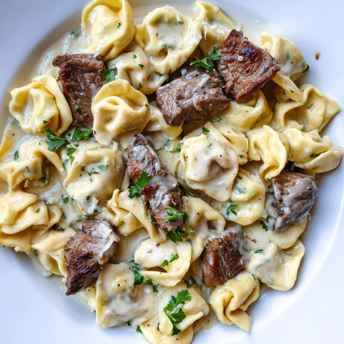 Sizzling steak bites and cheese tortellini coated in a velvety garlic cream sauce
