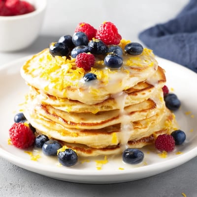 Bright Lemon Breakfast Pancake Stack drizzled with tangy glaze, served warm with a pat of butter melting on top.