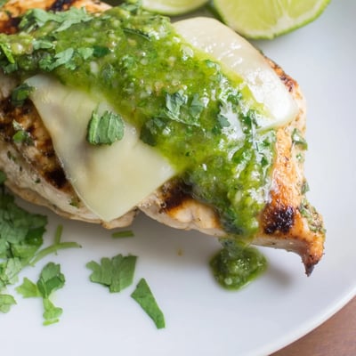 Serve this Grilled Salsa Verde Pepper Jack Chicken with lime wedges for a zesty summer meal.